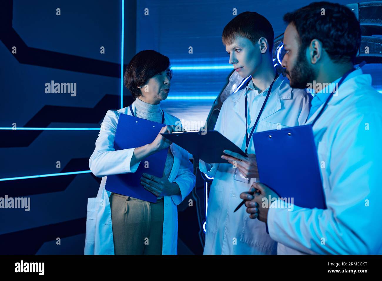 Female scientist passionately explains tasks to interns within a futuristic science center Stock Photo