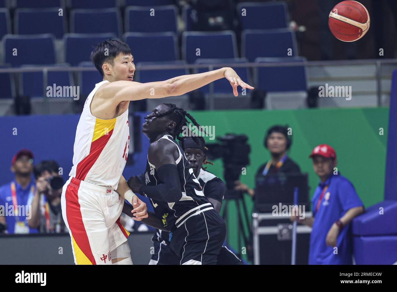 Manila, Philippines. 28th Aug, 2023. Zhou Qi (L) of China passes the ball  during the Group B match between China and South Sudan at the 2023 FIBA  World Cup in Manila, the