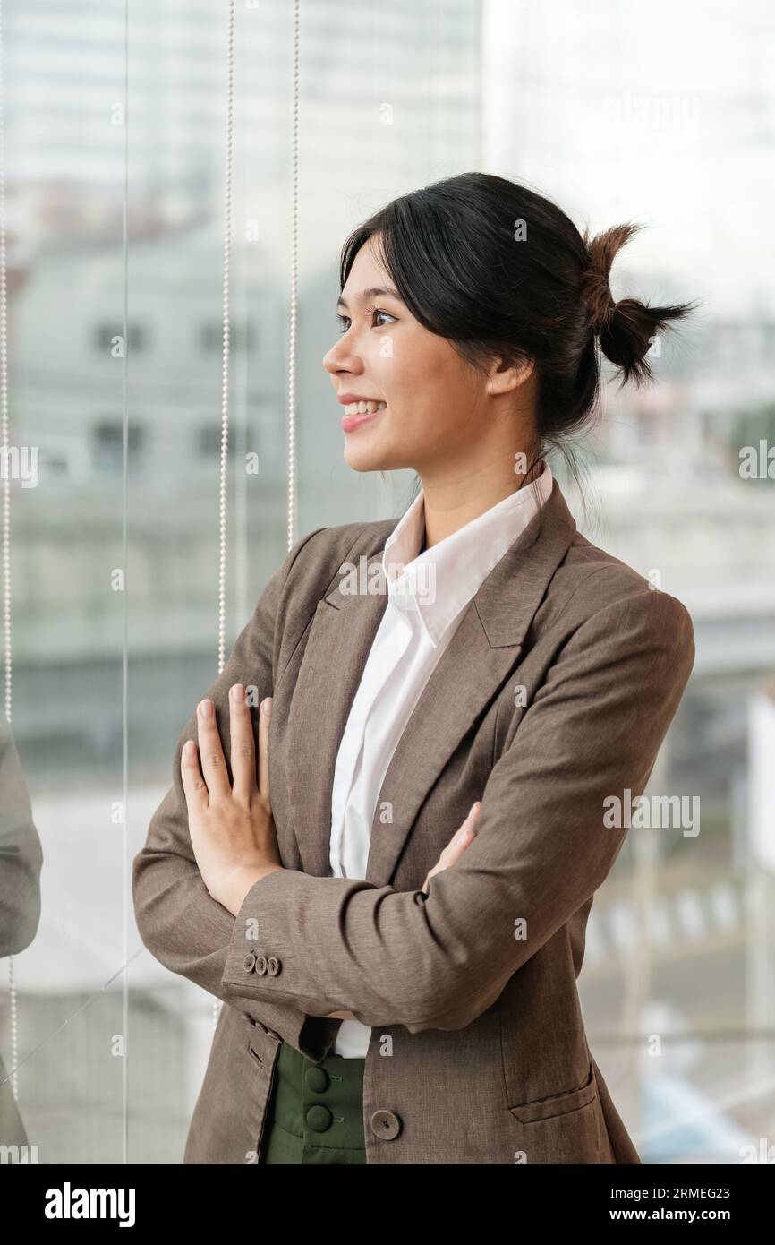 Confident Asian business woman standing and crossing her arms in office ...