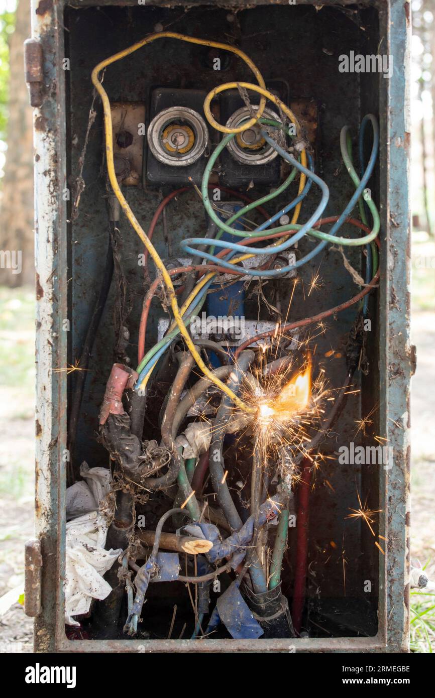 Vintage breaker box with dirty wires, sparks and flame, short circuit concept Stock Photo