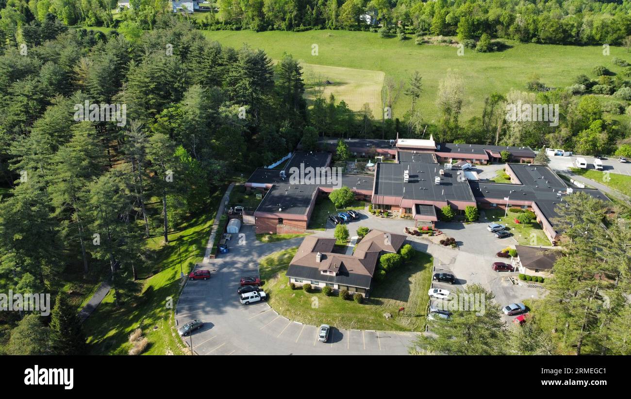 Aerial view of a facility embedded in a lush green forest, with a ...