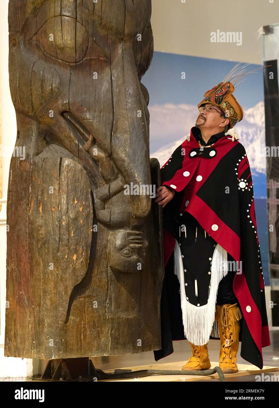Earl Stephen's(who has the Nisga'a cultural name Chief Ni'is Joohl) part of the delegation from the Nisga'a nation beside the 11-metre tall memorial pole during a visit to the National Museum of Scotland in Edinburgh, ahead of the return of 11-metre tall memorial pole to what is now British Columbia. The Nisga'a Lisims Government (NLG) and National Museums Scotland (NMS) announced last month that the House of Ni'isjoohl memorial pole will return home to the Nass Valley this September. Picture date: Monday August 28, 2023. Stock Photo