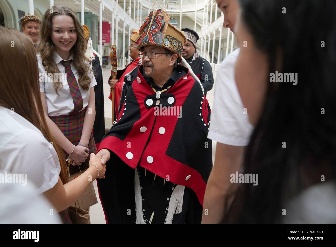 Earl Stephen's(who has the Nisga'a cultural name Chief Ni'is Joohl) part of the delegation from the Nisga'a nation thanks children from the Glasgow Gaelic School who performed during a visit to the National Museum of Scotland in Edinburgh, ahead of the return of 11-metre tall memorial pole to what is now British Columbia. The Nisga'a Lisims Government (NLG) and National Museums Scotland (NMS) announced last month that the House of Ni'isjoohl memorial pole will return home to the Nass Valley this September. Picture date: Monday August 28, 2023. Stock Photo