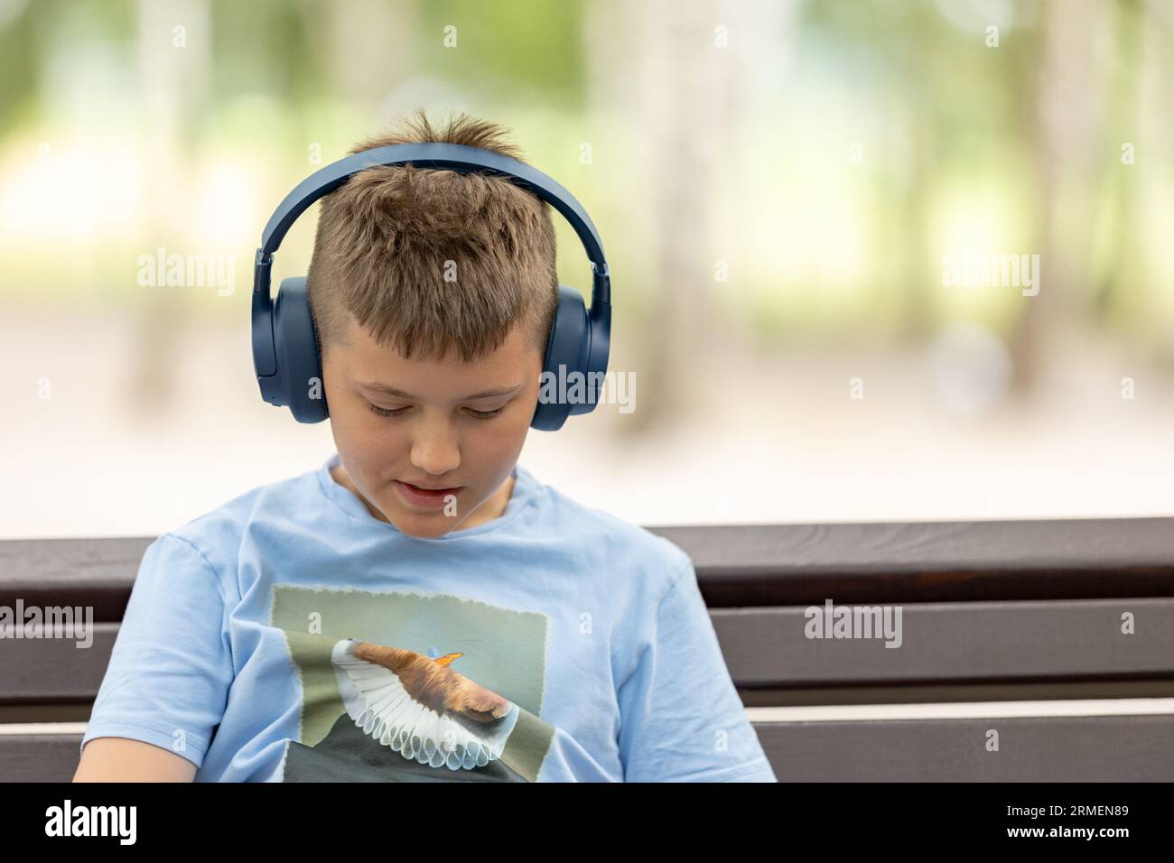 Laughing kid boy 10 year old with headphones outdoors. Childhood