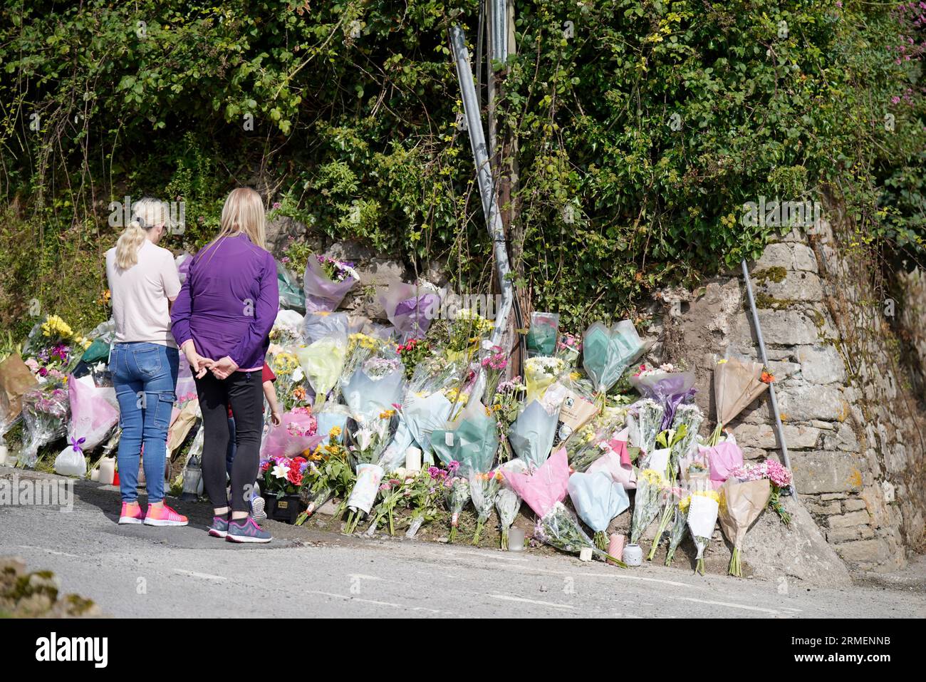 People view tributes at the scene of a crash, in memory of Luke McSweeney, 24, his sister Grace McSweeney, 18, Zoey Coffey, 18, and Nicole Murphy, 18, who all died while on the way to celebrate exam results when the car they were travelling in struck a wall and overturned in Clonmel on Friday. Picture date: Monday August 28, 2023. Stock Photo