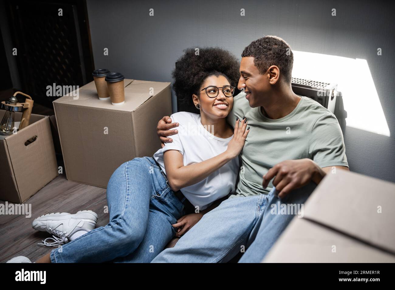 cheerful african american woman hugging boyfriend near coffee to go and ...