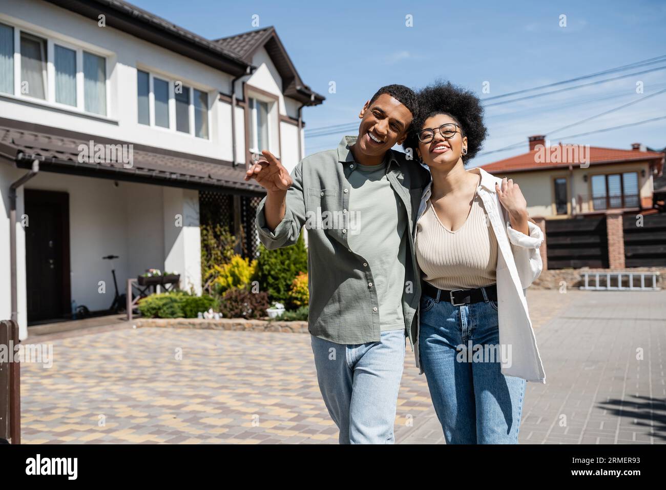 positive african american couple hugging and walking near blurred ...