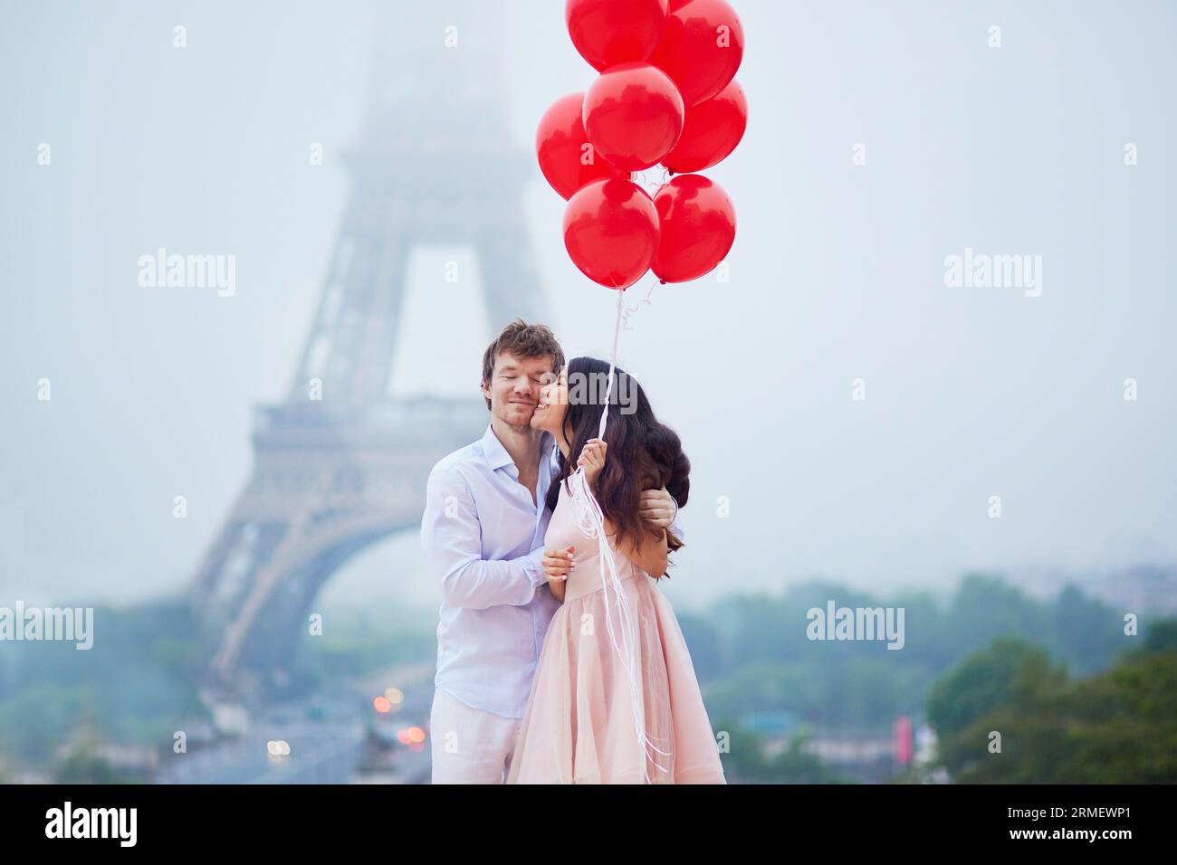 Beautiful romantic couple in love with bunch of red balloons together ...