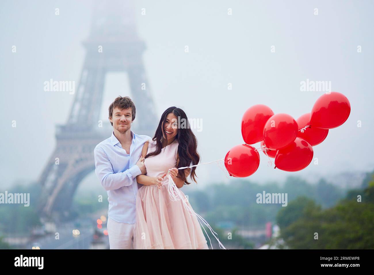 Beautiful romantic couple in love with bunch of red balloons together ...