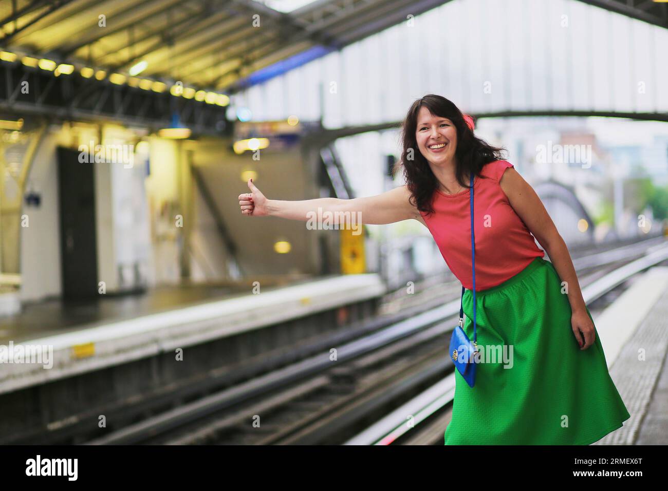 Cheerful young woman in Paris having fun in Parisian underground and ...