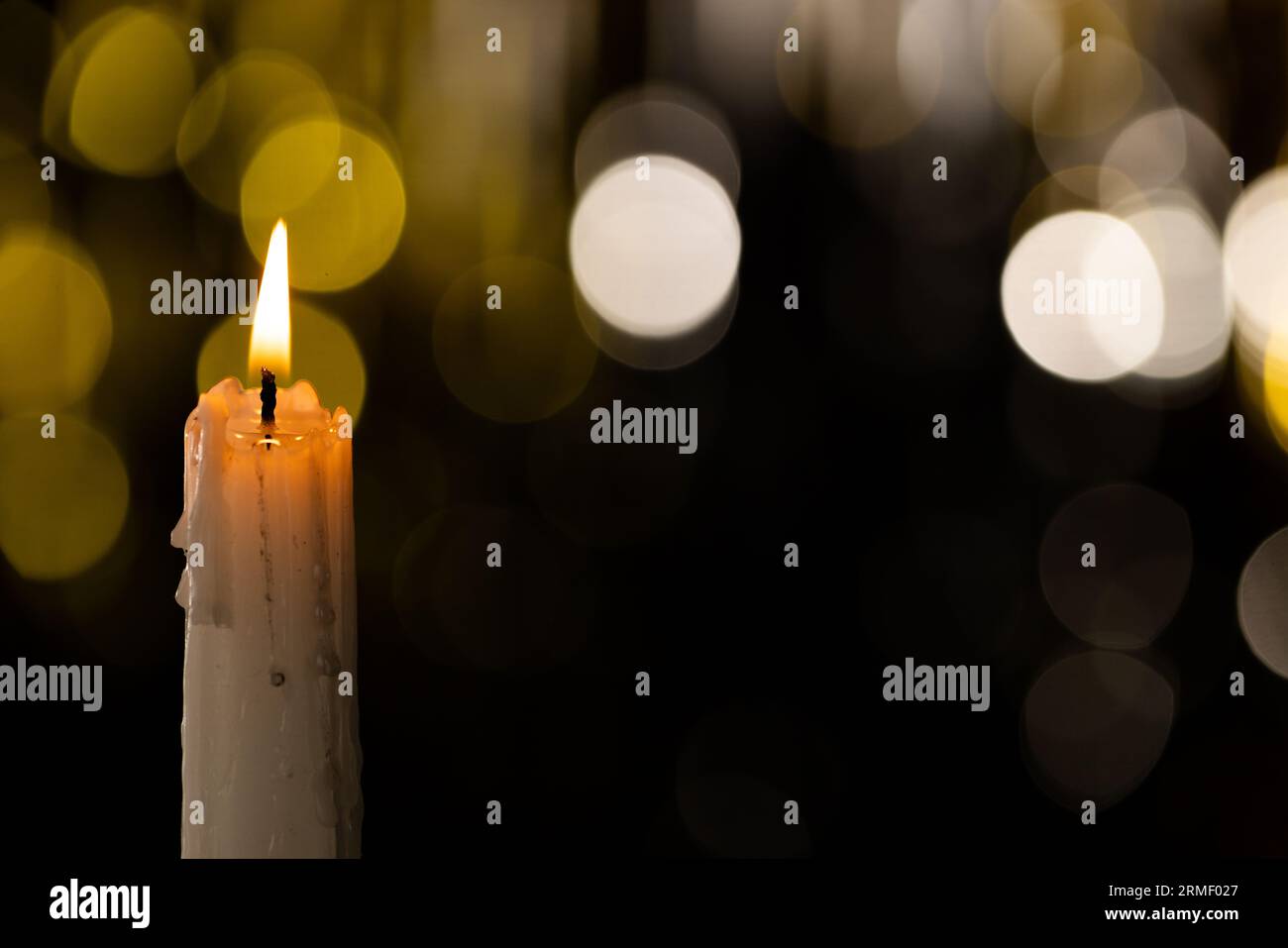 Lit white candle and bokeh with copy space on black background Stock ...