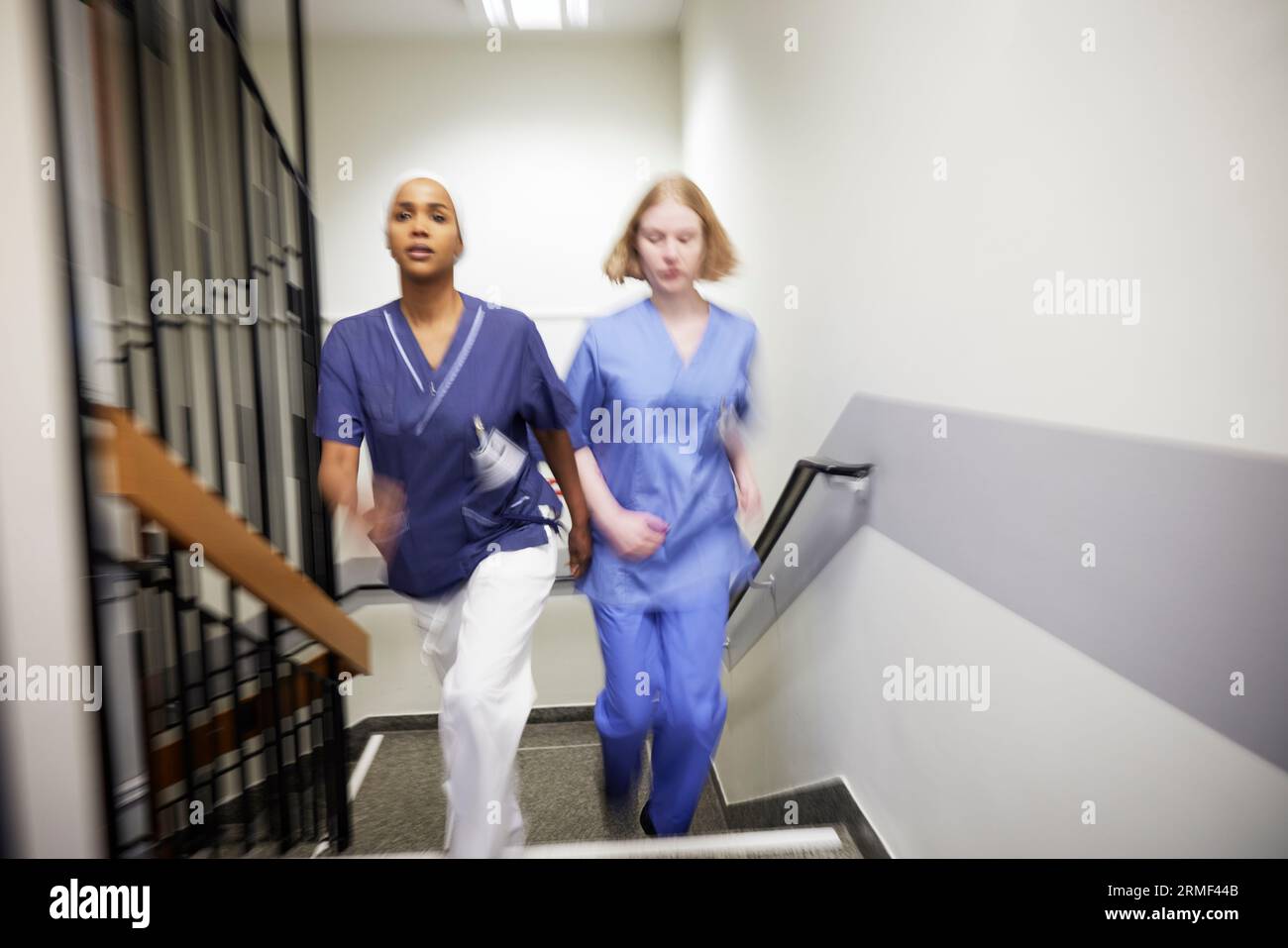 Female doctors walking at staircase together Stock Photo