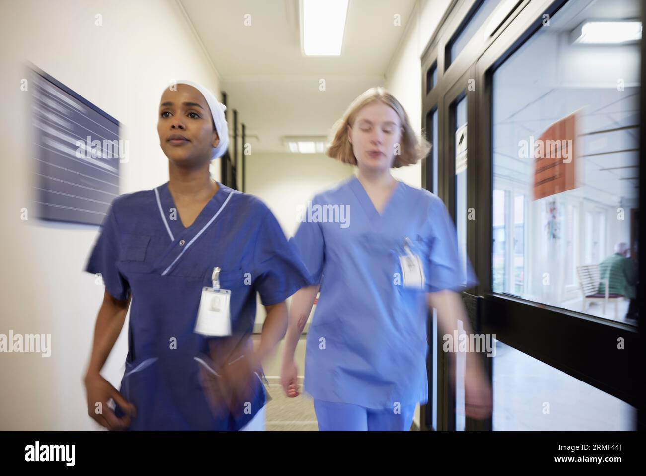Female doctors walking through hospital corridor Stock Photo