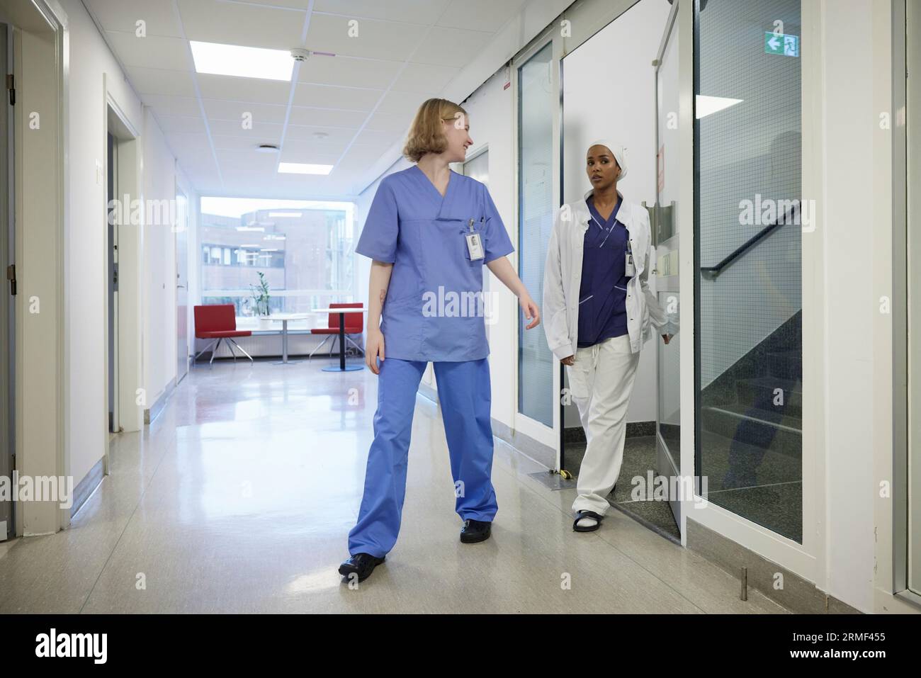 Female doctors walking through hospital corridor Stock Photo