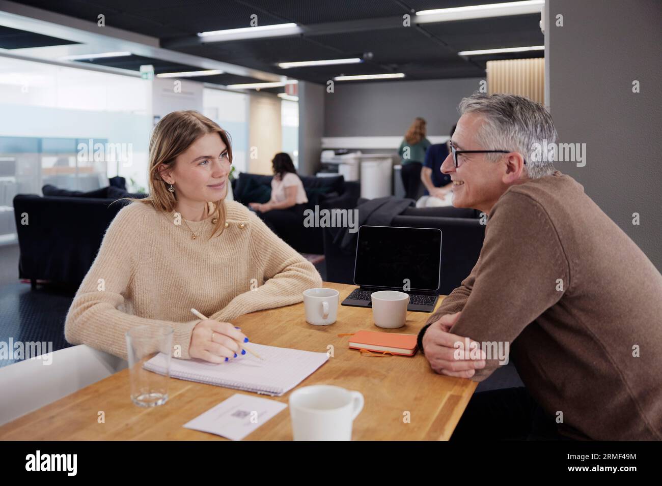 Two professionals working together in office cafeteria Stock Photo
