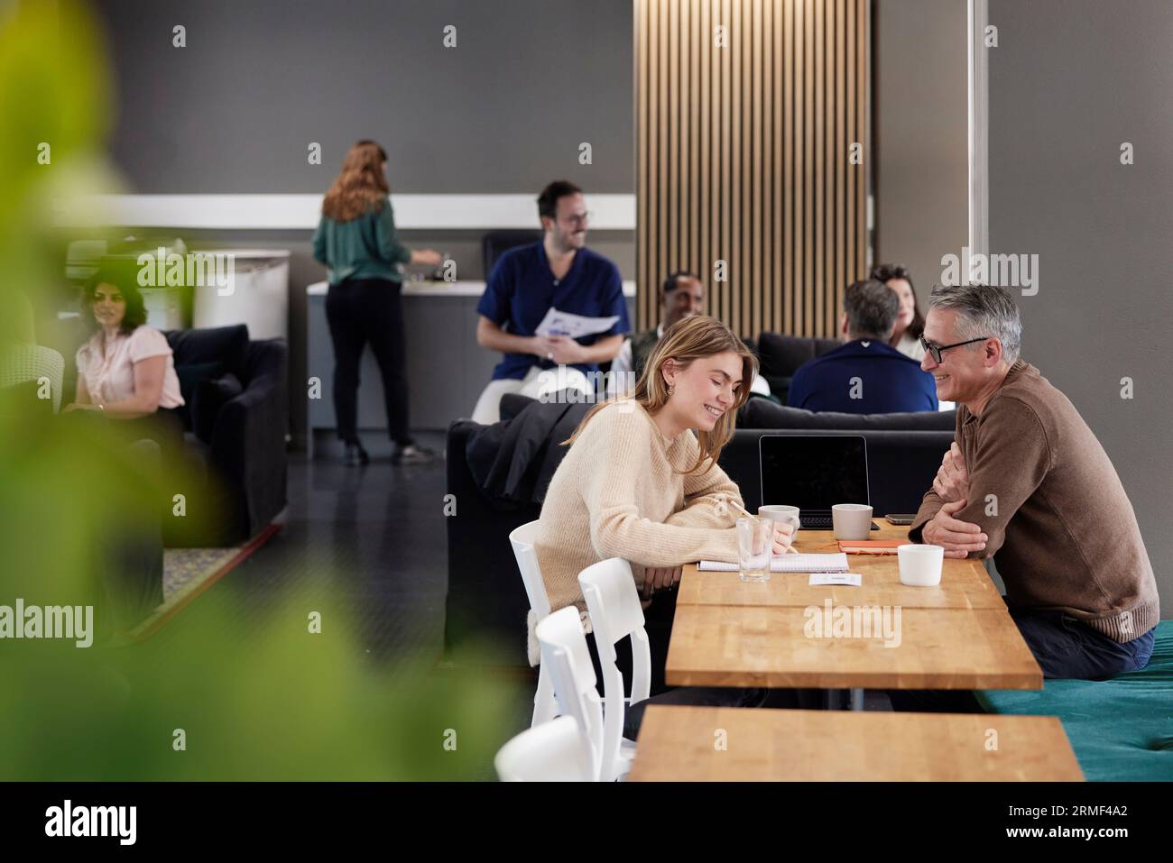 Two professionals working together in office cafeteria Stock Photo