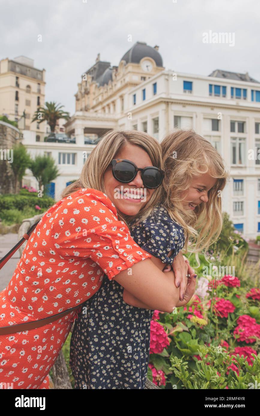 Cheerful mother and daughter posing in front of historical building Stock Photo