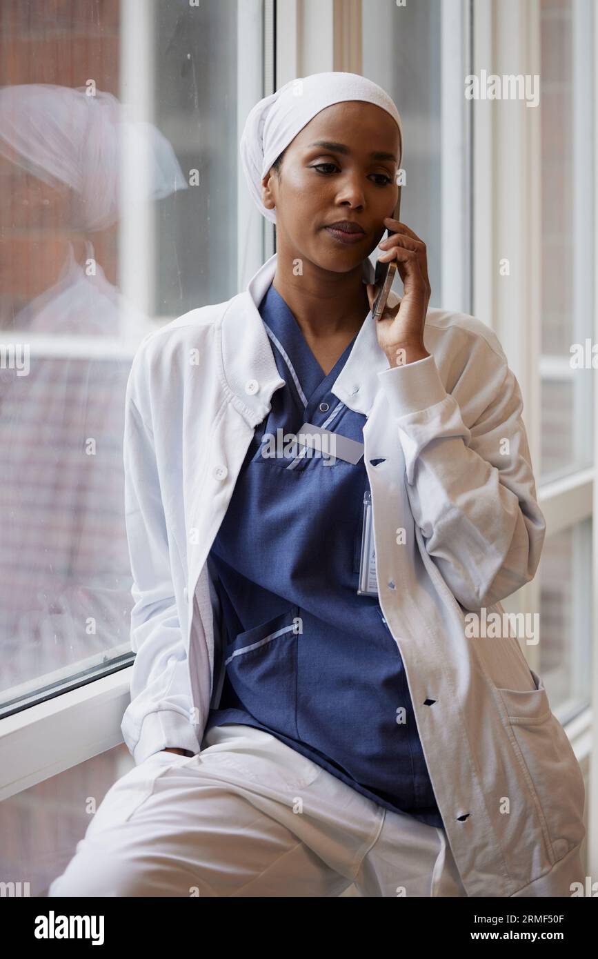Young female doctor talking on phone at work Stock Photo - Alamy