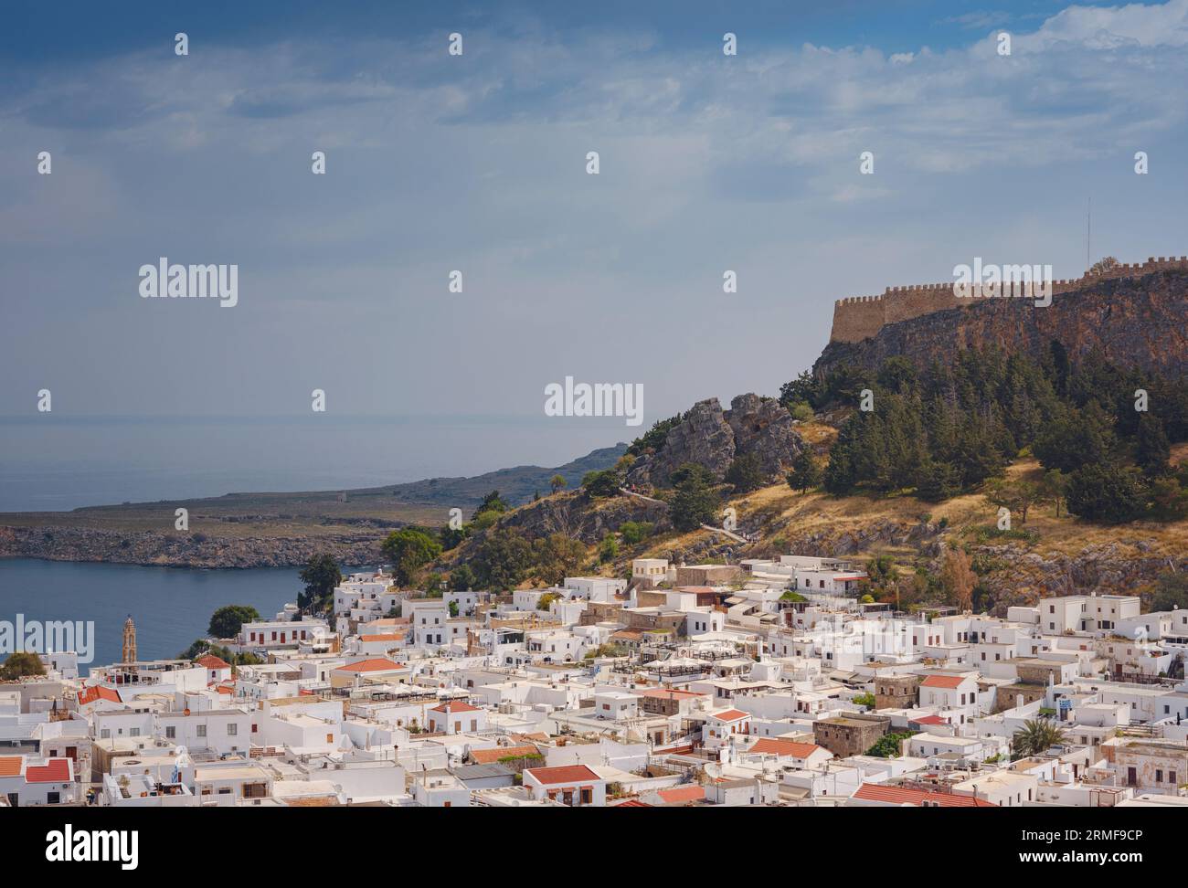 Lindos town in Greece aerial view in cloud summer day, white houses in Rhodes island , cityscape viewpoint traditional greek architecture, famous land Stock Photo