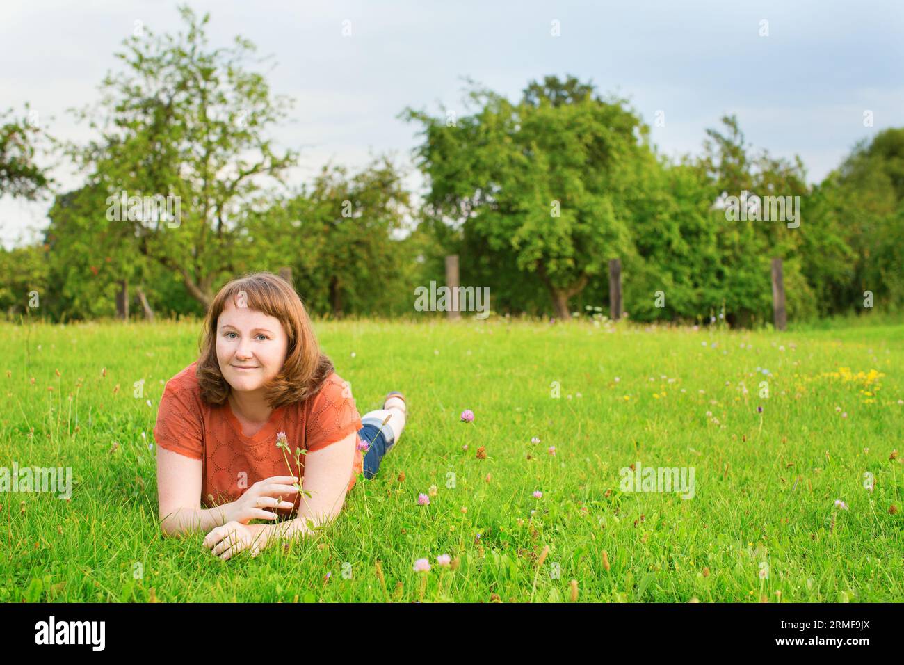 Smiling girl lying on the grass on a summer day Stock Photo - Alamy