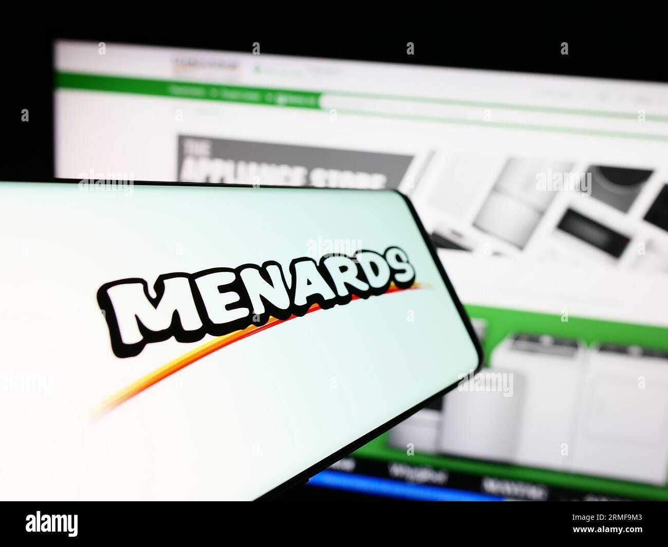 Smartphone with logo of American retail company Menard Inc. (Menards) on screen in front of website. Focus on center-left of phone display. Stock Photo