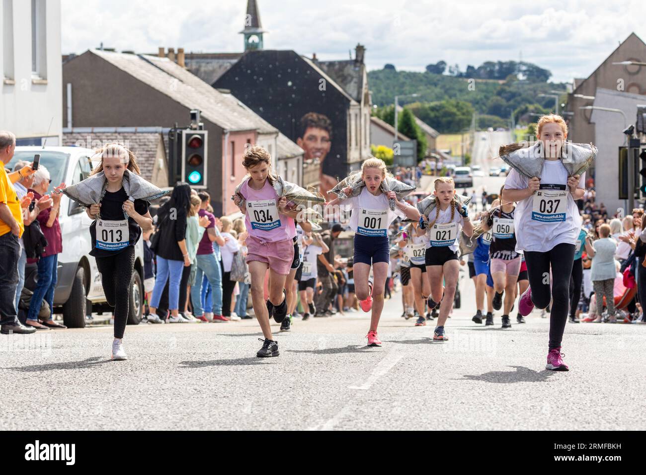 Girls taking part in the Scottish Coal Carrying Championships through the streets of Kelty in Fife Stock Photo