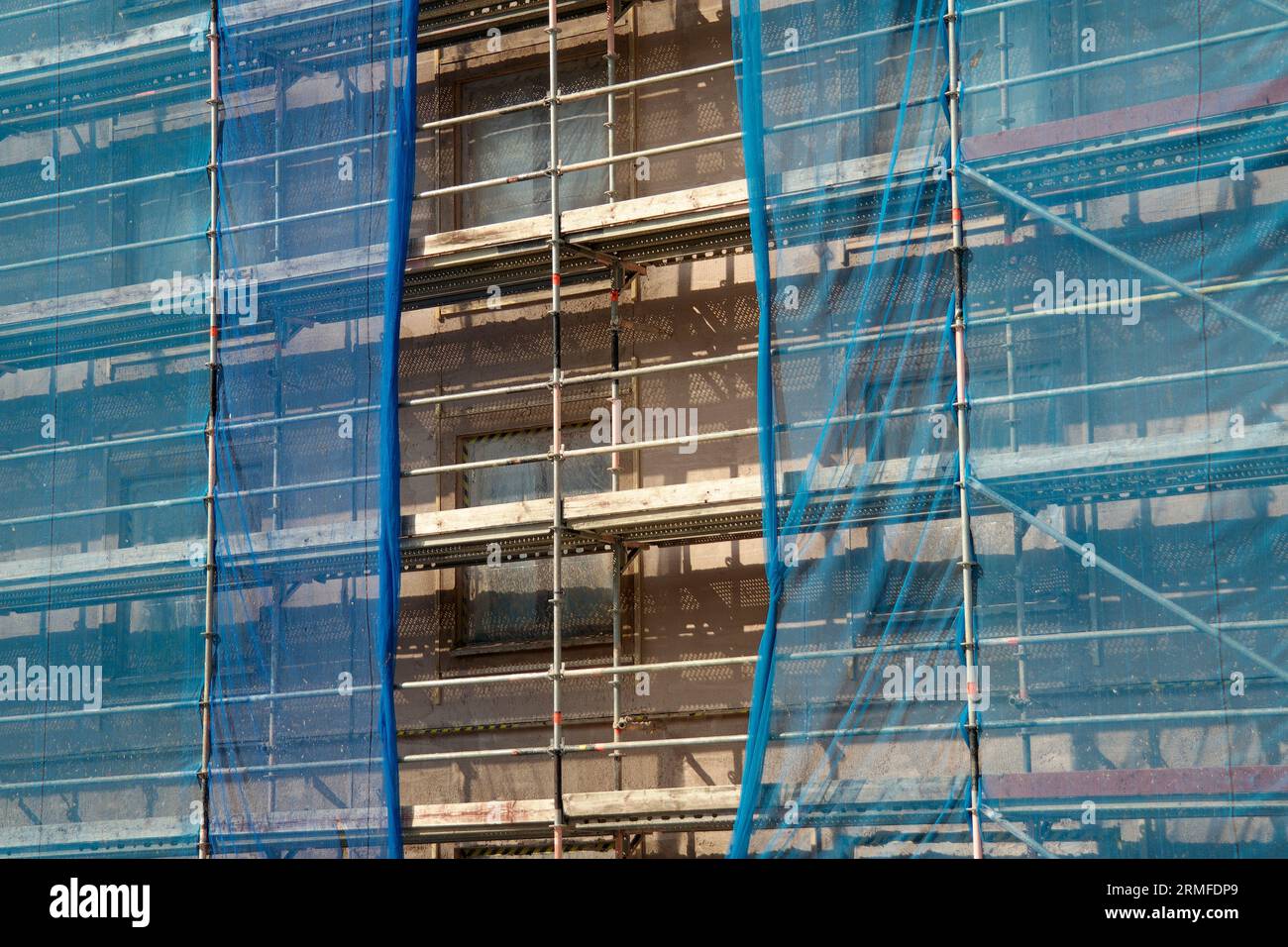 Scaffolding and netting in a construction site Stock Photo