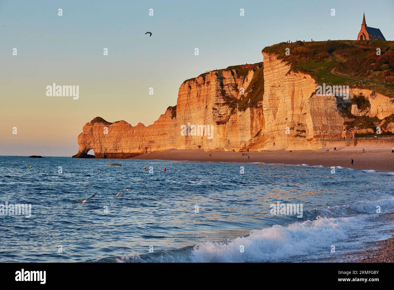 Scenic view of Etretat with its beach and famous cliffs with arches at ...