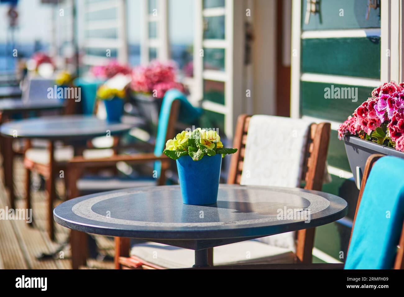 Wooden table decorated with flower pot, candles and lantern in outdoor cafe in Marken, the Netherlands Stock Photo