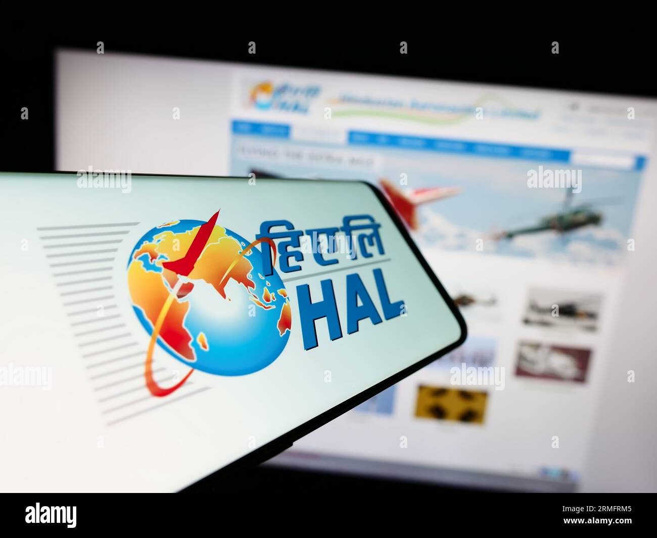 Cellphone with logo of company Hindustan Aeronautics Limited (HAL) on screen in front of business website. Focus on center of phone display. Stock Photo