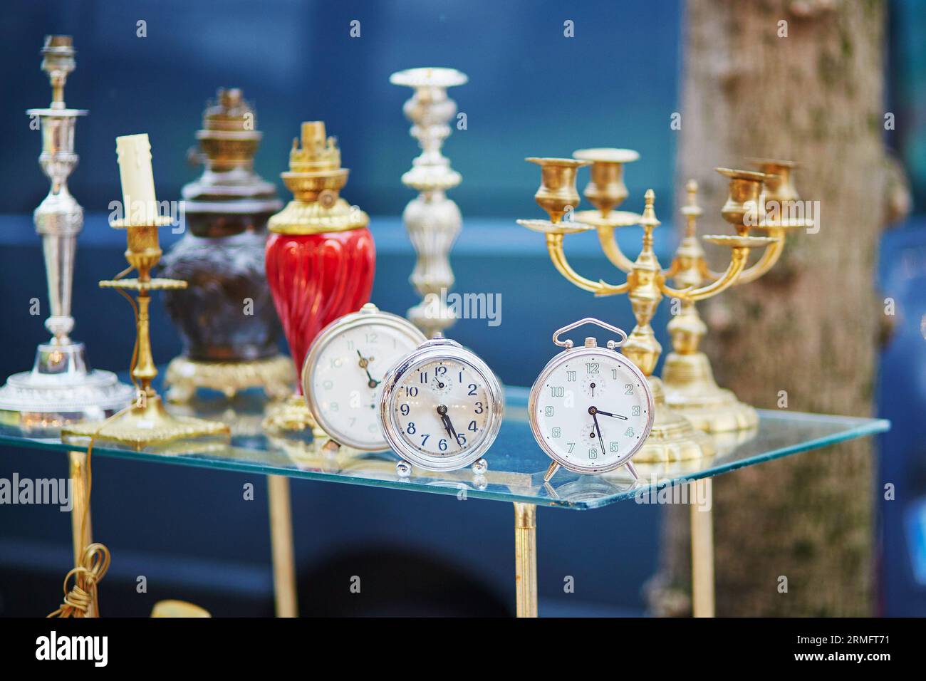 Old alarm clocks and candle holders on flea market in Paris, France Stock Photo