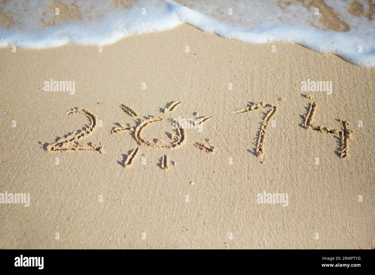 2014 written in sand on beach texture Stock Photo - Alamy