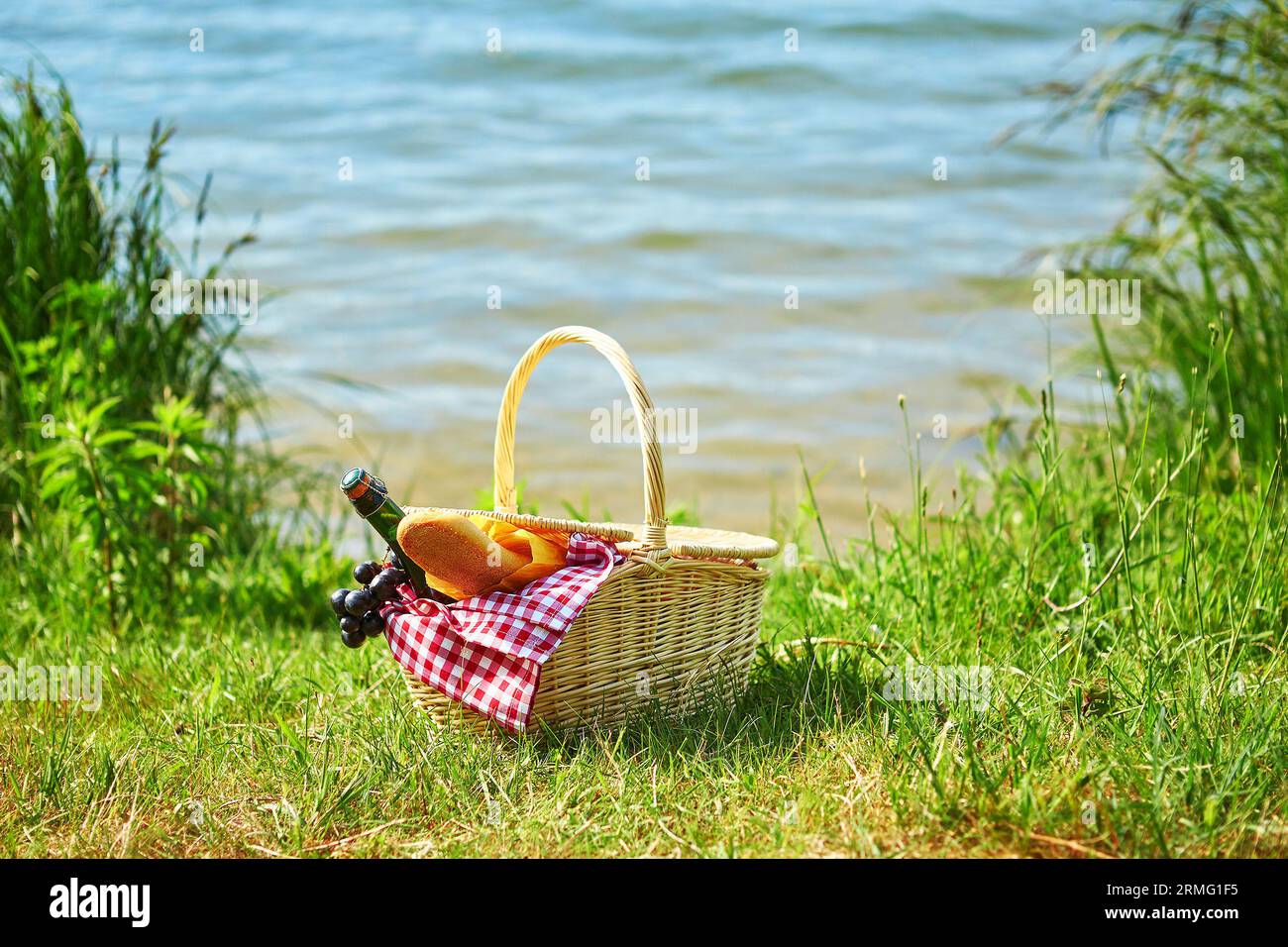 Picnic basket with food and cider bottle near the water Stock Photo - Alamy