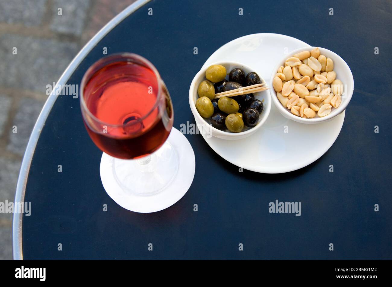 Parisian street cafe table with traditional French aperitif kir cassis and nibbles. Focus on