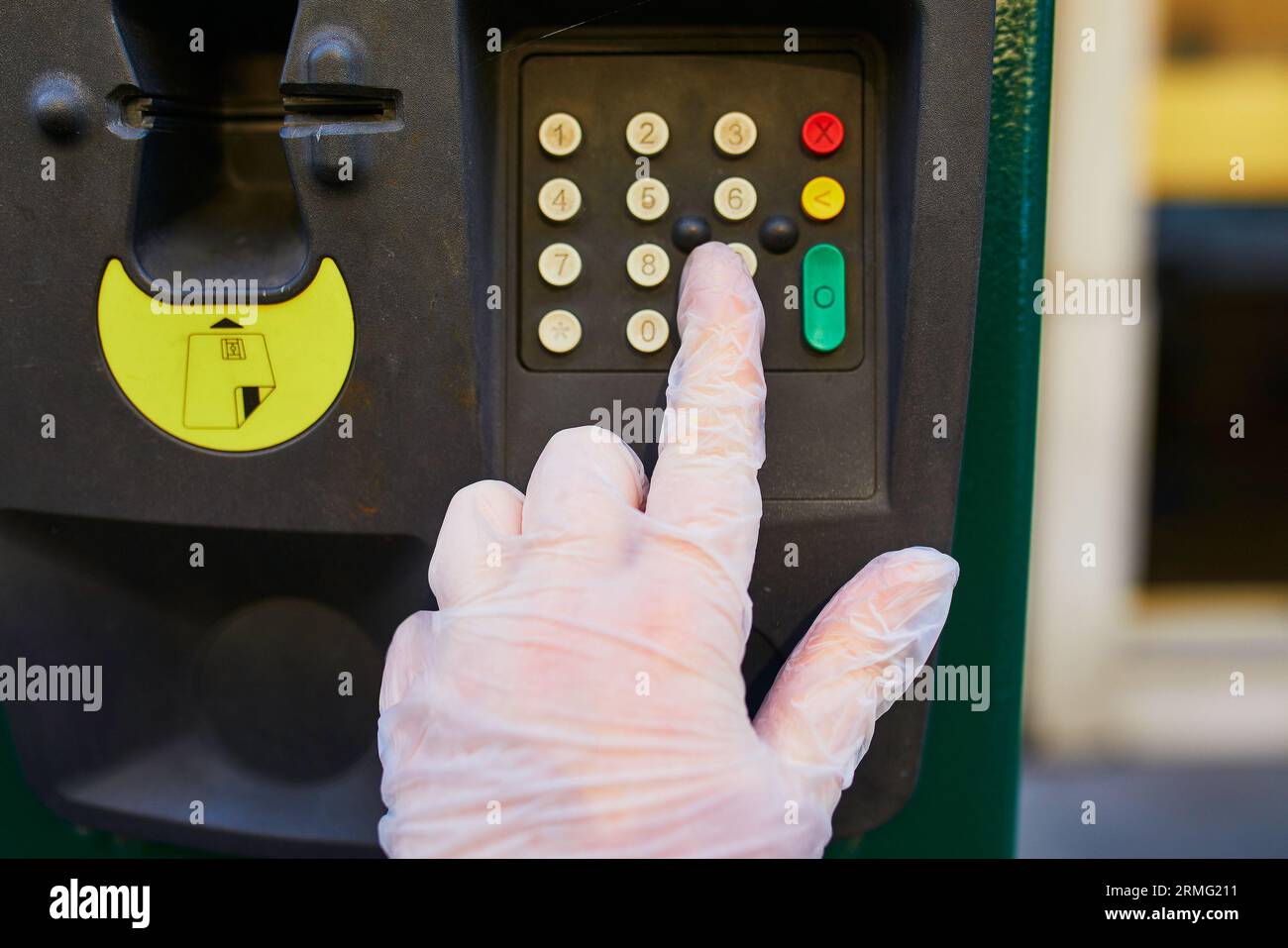 Woman hand in protective single use glove presses parking meter button ...