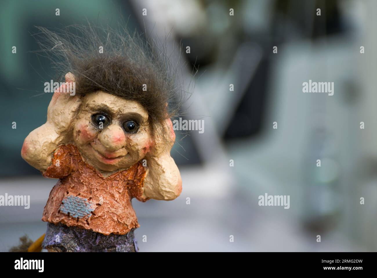 A small Norwegian troll covering his eares. Trolls are famous creatures in Scandinavian myth. Very detailed image with copyspace. Stock Photo