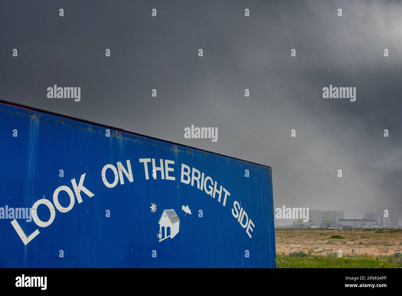 Dungeness Power station in the background with a 'Look On the Bright Sude' sign in the foreground Stock Photo