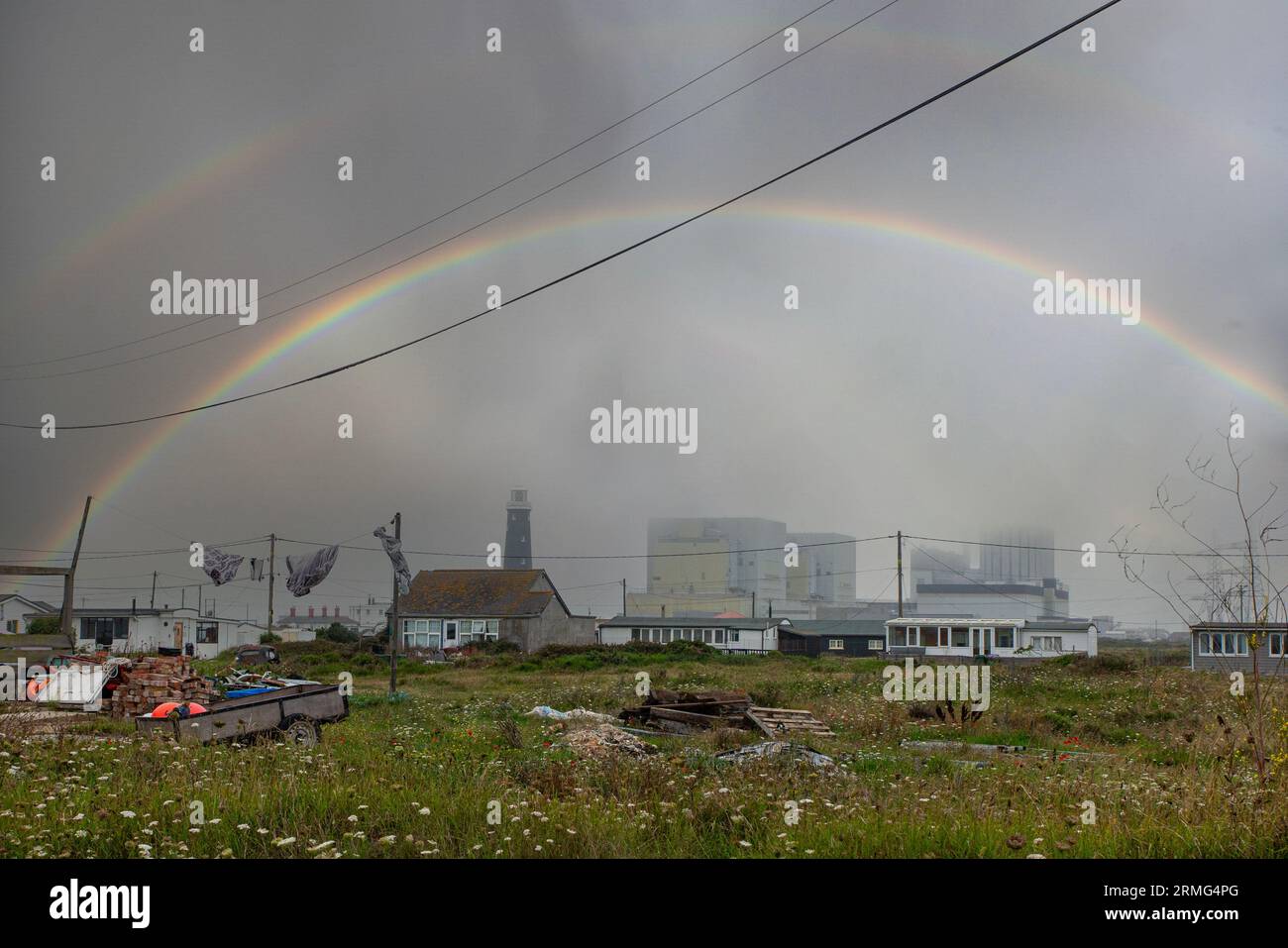 Dungeness Power station and old lighthouse under a double rainbow Stock Photo