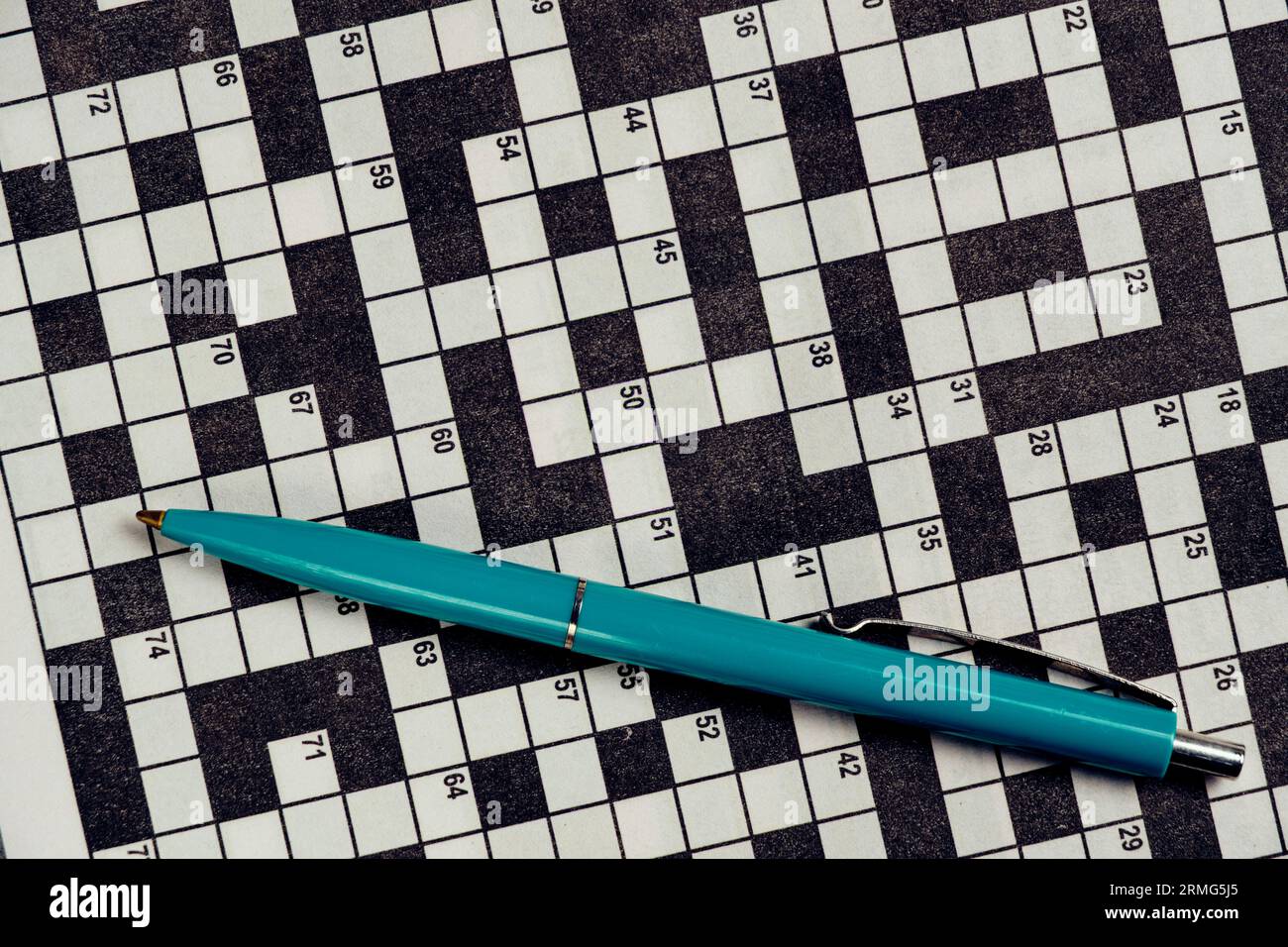 Ballpoint pen is lying on piece with crossword puzzle.Hobby concept and