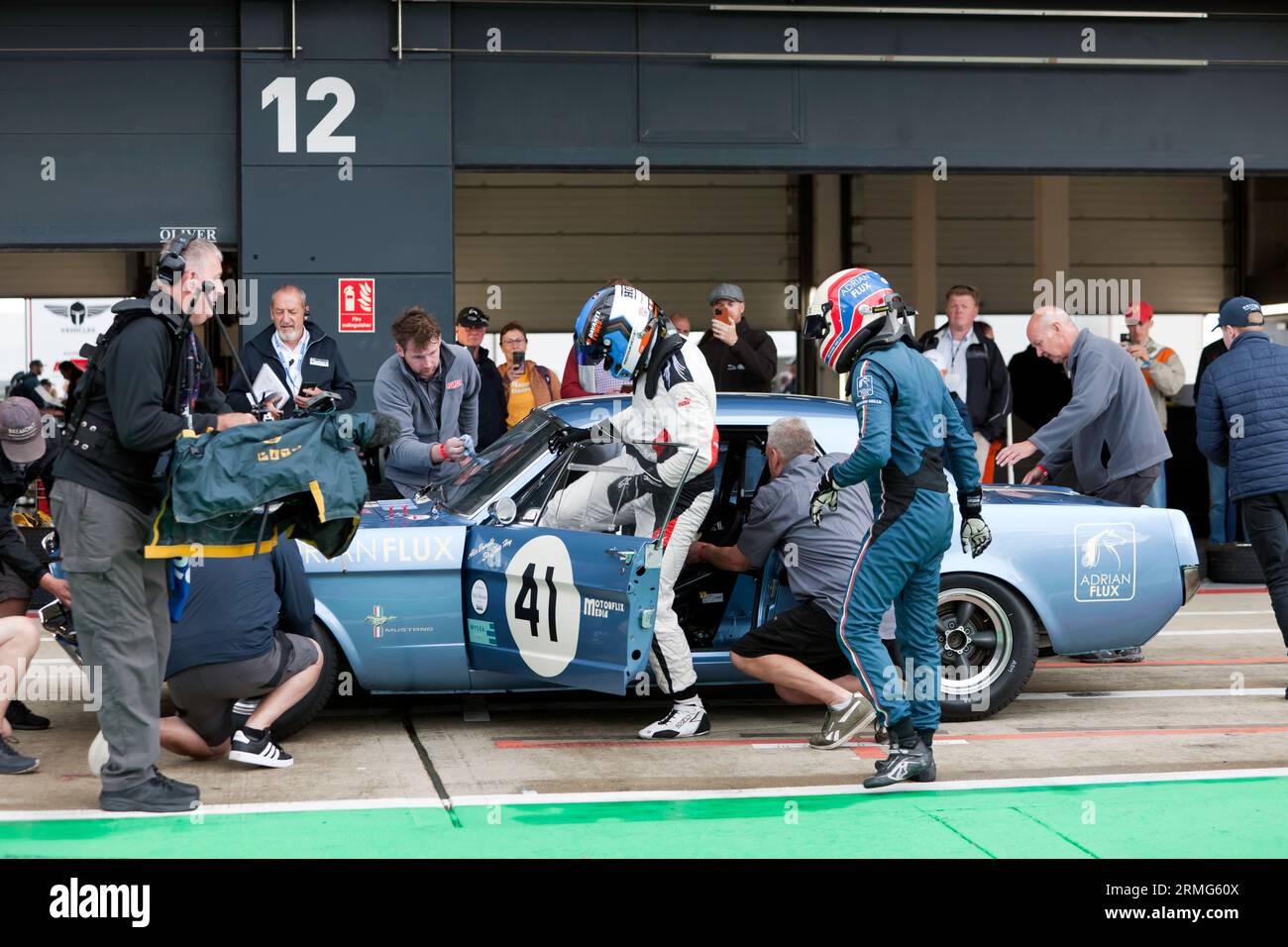 Sir Chris Hoy, changes places with Alex Brundle, in their 1965 Ford Mustang, during the  Adrian Flux Trophy for TransAtlantic Pre ’66 Touring Cars. Stock Photo