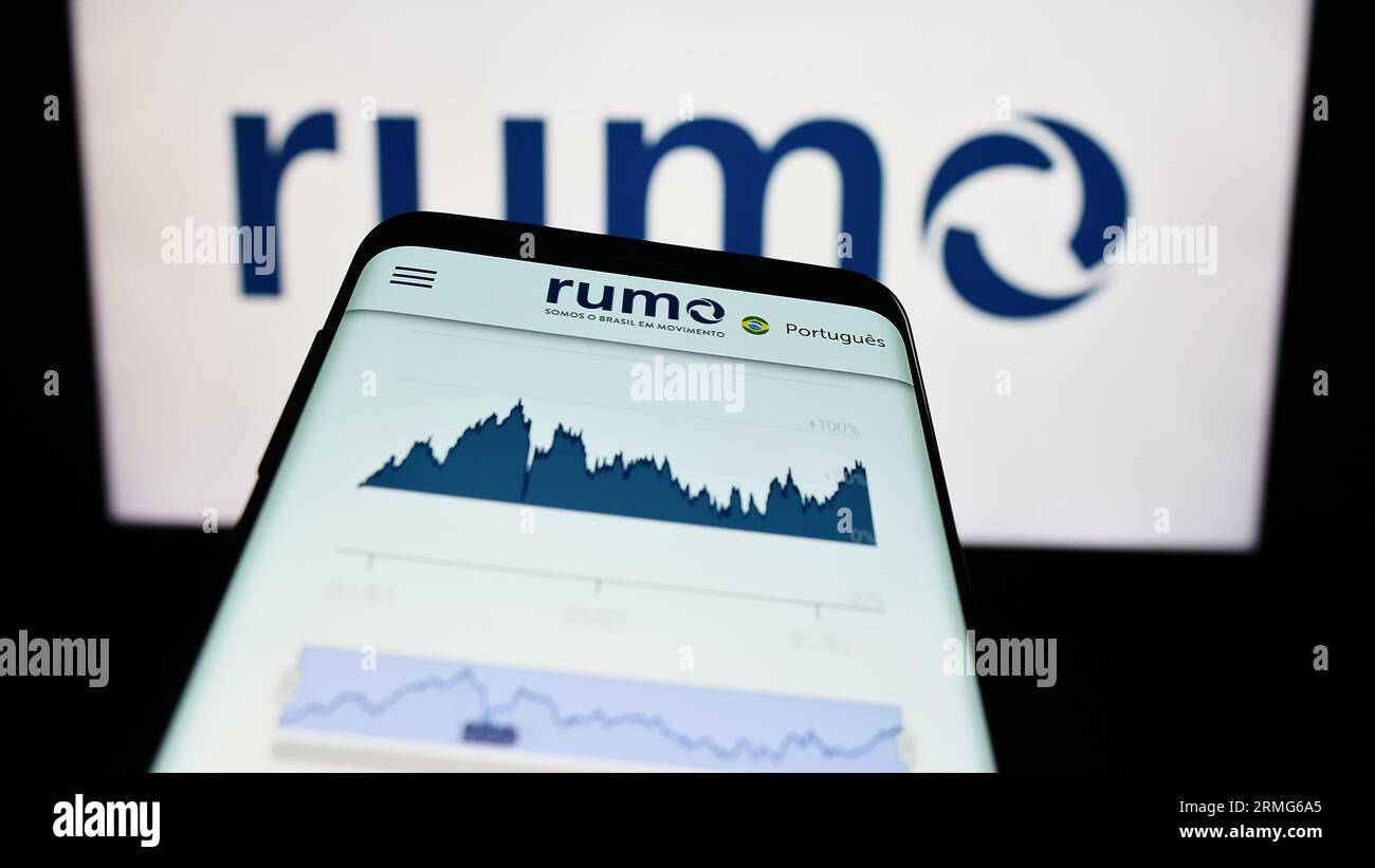 Mobile phone with webpage of Brazilian logistics company Rumo S.A. on screen in front of business logo. Focus on top-left of phone display. Stock Photo