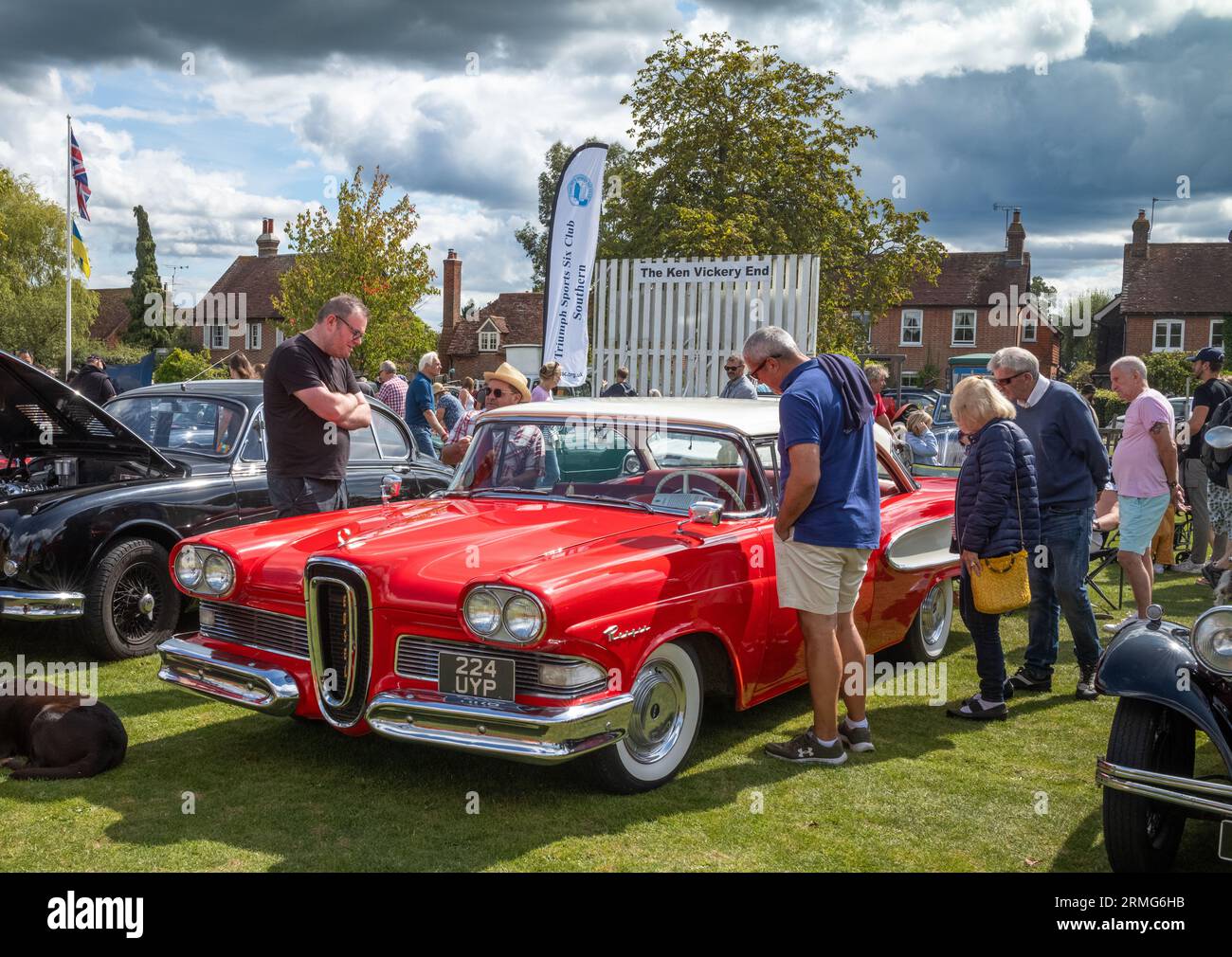 People stop to look at a bright red 1958 Ford Edsel car from the USA at Wisborough Green Village Fete, West Sussex, UK. The car, when it was launched, Stock Photo