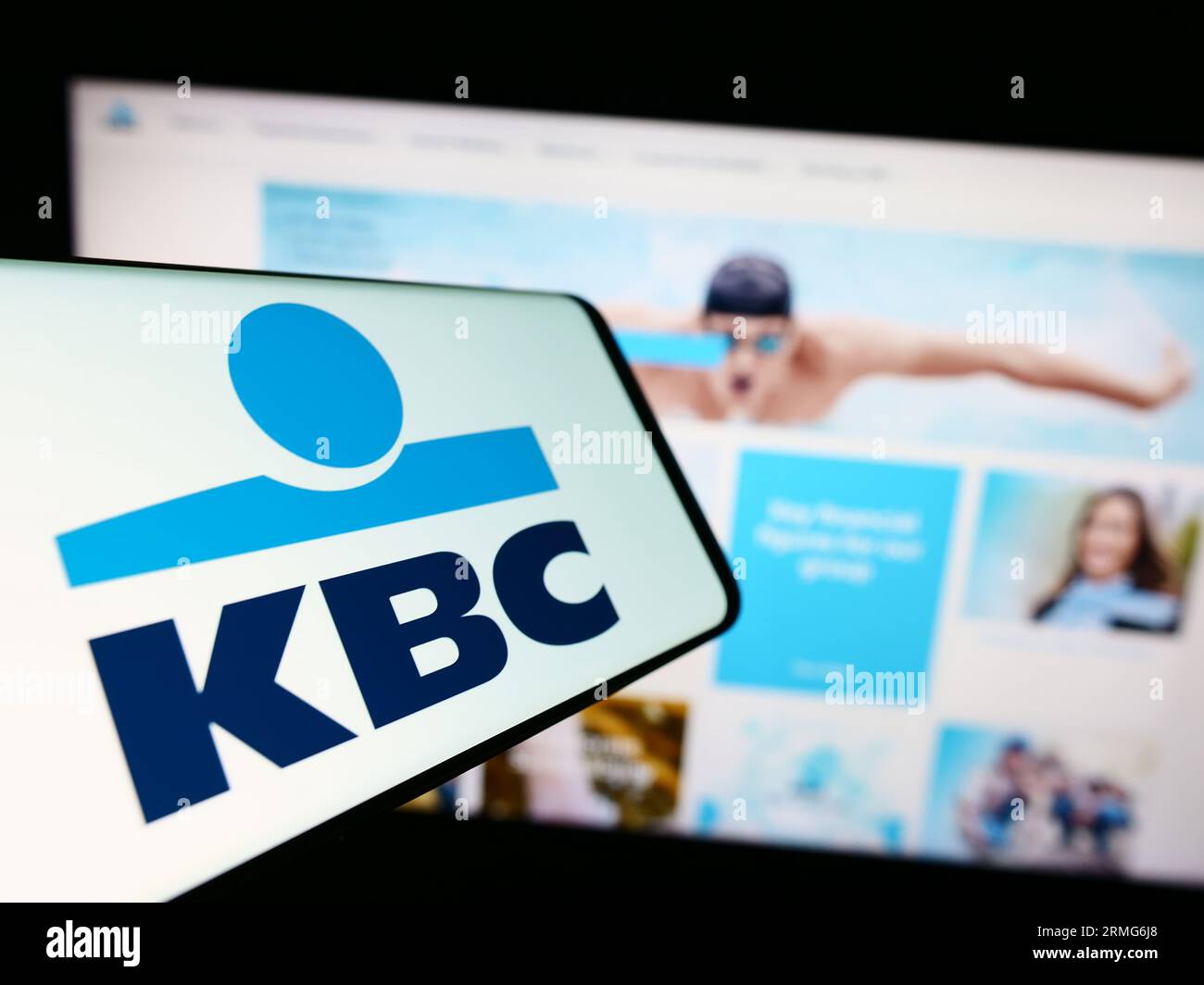 Mobile phone with logo of Belgian financial company KBC Group NV  on screen in front of business website. Focus on center of phone display. Stock Photo
