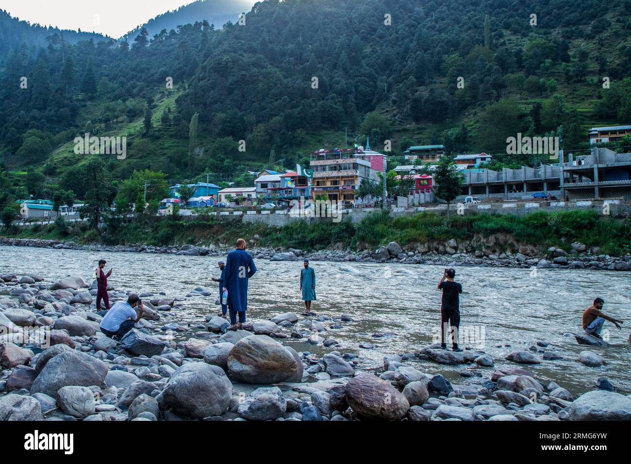 Keran Kupwara, India. 24th Aug, 2023. People are seen filming and enjoying view of Pakistan administered Kashmir on the banks of Neelam river or Kishan Ganga that has divided Kashmir into two parts controlled by nuclear rivals India and Pakistan. The river acts as a disputed line of control and flows through a village called Keran from both sides which is located on the northern side of Indian Kashmir's Border district Kupwara some 150kms from Srinagar and 93kms from Muzaffarabad, in the Pakistan side of Kashmir. (Photo by Faisal Bashir/SOPA Images/Sipa USA) Credit: Sipa USA/Alamy Live News Stock Photo