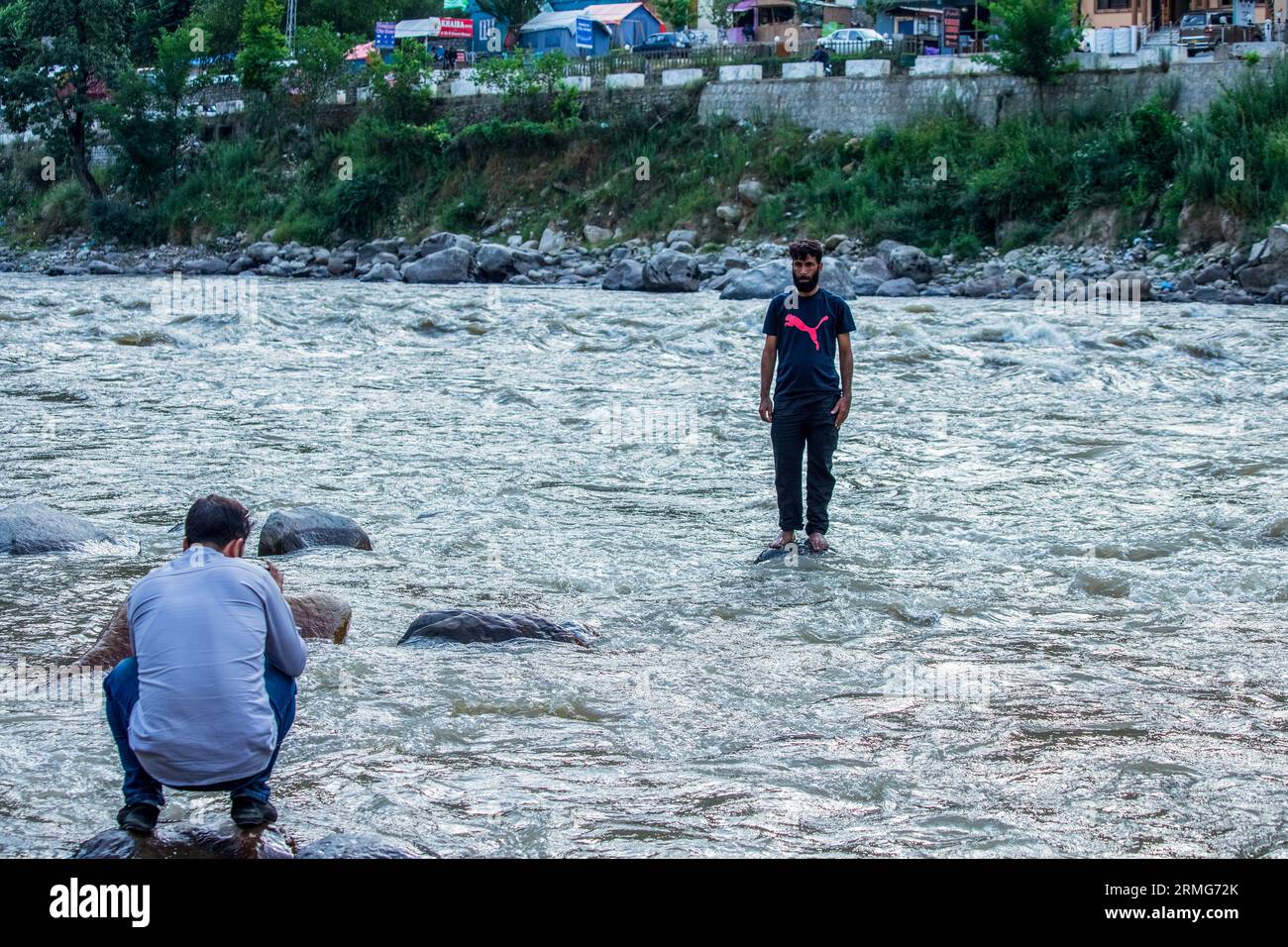 Keran Kupwara, India. 24th Aug, 2023. A local visitor seen taking photos of his friend on the banks of Neelam river or Kishan Ganga that has divided Kashmir into two parts controlled by nuclear rivals India and Pakistan. The river acts as a disputed line of control and flows through a village called Keran from both sides which is located on the northern side of Indian Kashmir's Border district Kupwara some 150kms from Srinagar and 93kms from Muzaffarabad, in the Pakistan side of Kashmir. (Photo by Faisal Bashir/SOPA Images/Sipa USA) Credit: Sipa USA/Alamy Live News Stock Photo