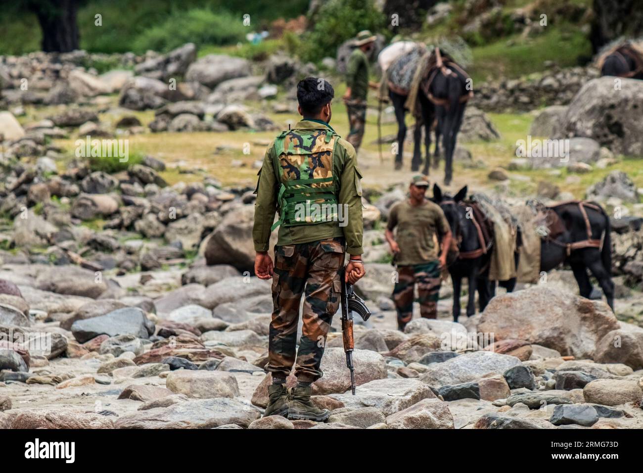 Indian army soldier stands guard as other colleagues seen with their horses as they prepare to head towards their bunkers, at Neelam river or Kishan Ganga that has divided Kashmir into two parts controlled by nuclear rivals India and Pakistan. The river acts as a disputed line of control and flows through a village called Keran from both sides which is located on the northern side of Indian Kashmir's Border district Kupwara some 150kms from Srinagar and 93kms from Muzaffarabad, in the Pakistan side of Kashmir. (Photo by Faisal Bashir/SOPA Images/Sipa USA) Stock Photo