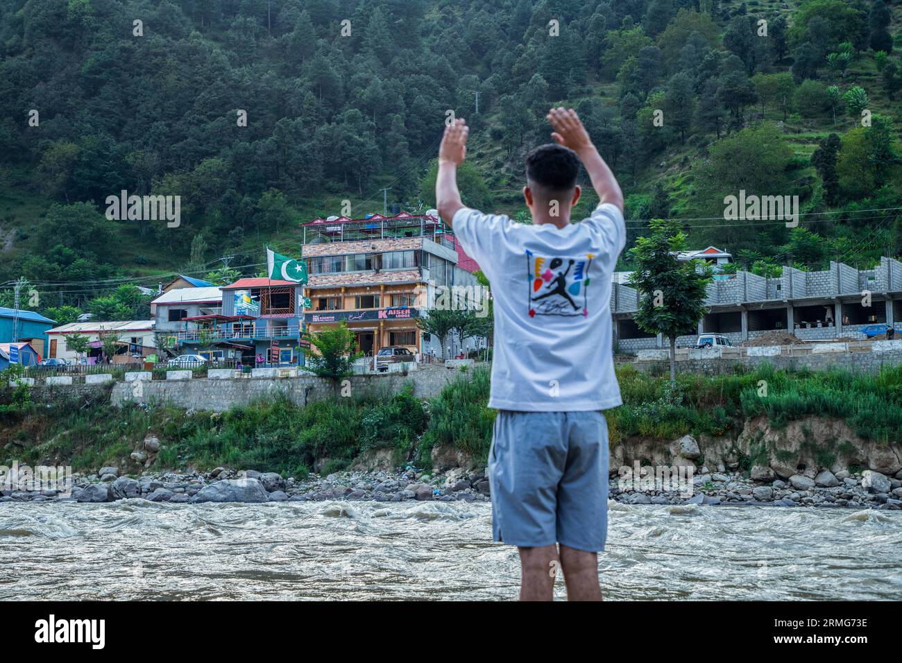 Keran Kupwara, India. 24th Aug, 2023. A local visitor waving to people in Pakistan Administered Kashmir on the banks of Neelam river or Kishan Ganga that has divided Kashmir into two parts controlled by nuclear rivals India and Pakistan. The river acts as a disputed line of control and flows through a village called Keran from both sides which is located on the northern side of Indian Kashmir's Border district Kupwara some 150kms from Srinagar and 93kms from Muzaffarabad, in the Pakistan side of Kashmir. (Photo by Faisal Bashir/SOPA Images/Sipa USA) Credit: Sipa USA/Alamy Live News Stock Photo