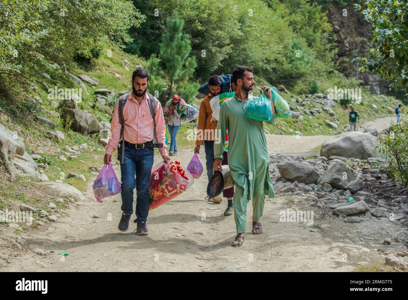 People in Indian Administered Kashmir walk along with food items and blankets as they prepare for camping on the banks of Neelam river or Kishan Ganga that has divided Kashmir into two parts controlled by nuclear rivals India and Pakistan. The river acts as a disputed line of control and flows through a village called Keran from both sides which is located on the northern side of Indian Kashmir's Border district Kupwara some 150kms from Srinagar and 93kms from Muzaffarabad, in the Pakistan side of Kashmir. (Photo by Faisal Bashir/SOPA Images/Sipa USA) Stock Photo