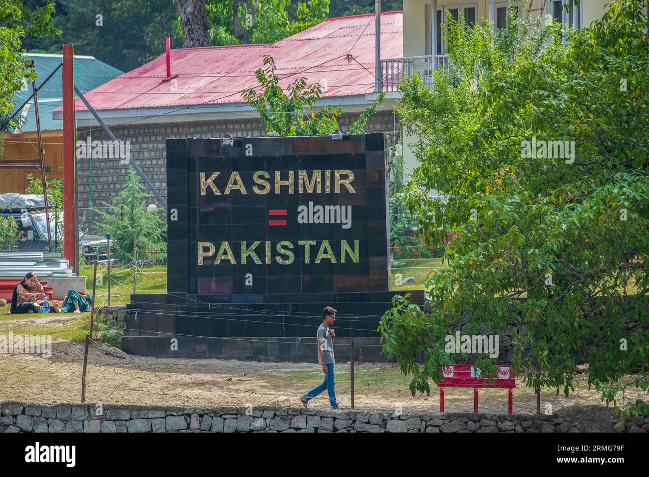 A boy in Pakistan Administered Kashmir walks past a board that says 'Kashmir=Pakistan' installed on the banks of Neelam river or Kishan Ganga that has divided Kashmir into two parts controlled by nuclear rivals India and Pakistan. The river acts as a disputed line of control and flows through a village called Keran from both sides which is located on the northern side of Indian Kashmir's Border district Kupwara some 150kms from Srinagar and 93kms from Muzaffarabad, in the Pakistan side of Kashmir. (Photo by Faisal Bashir/SOPA Images/Sipa USA) Stock Photo