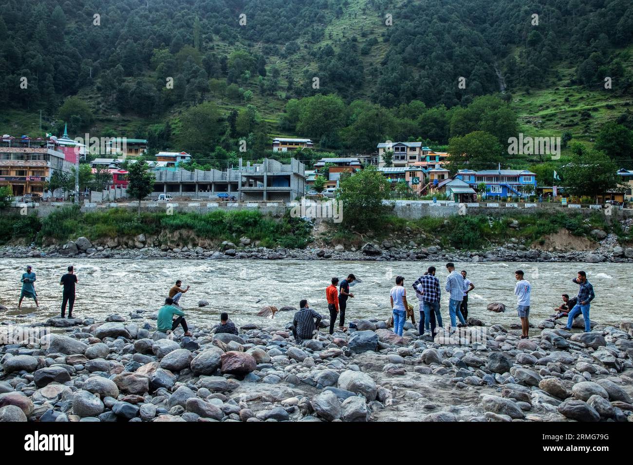 Keran Kupwara, India. 24th Aug, 2023. People are seen enjoying view of Pakistan administered Kashmir on the banks of Neelam river or Kishan Ganga that has divided Kashmir into two parts controlled by nuclear rivals India and Pakistan. The river acts as a disputed line of control and flows through a village called Keran from both sides which is located on the northern side of Indian Kashmir's Border district Kupwara some 150kms from Srinagar and 93kms from Muzaffarabad, in the Pakistan side of Kashmir. (Photo by Faisal Bashir/SOPA Images/Sipa USA) Credit: Sipa USA/Alamy Live News Stock Photo